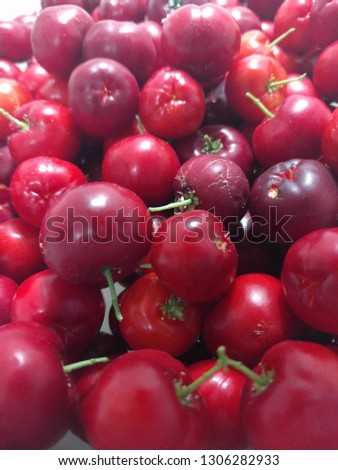 Textural background of red cherries and various sizes. Collection of very fresh red cherries in vertical