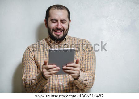 Happy man with a modern smartphone in his hands, playing in games. The man with a smile and beauty shows different emotions on a white background.
