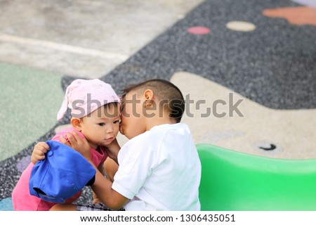 Happy Valentine 's day and love concept, a young brother kiss and hugging his baby sister at the playground.
