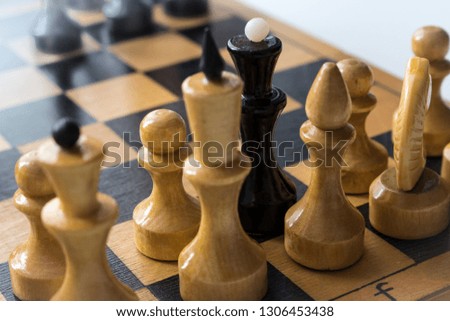 black Chess Queen with white chess pieces on the Board