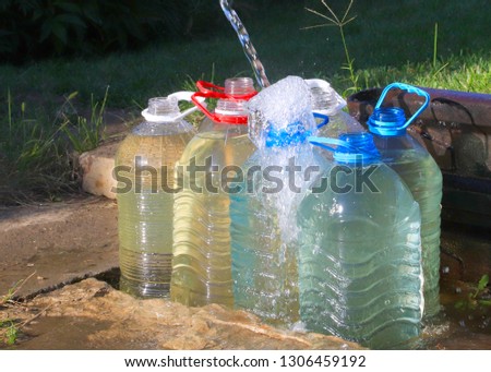 pouring clear water into plastic bottles