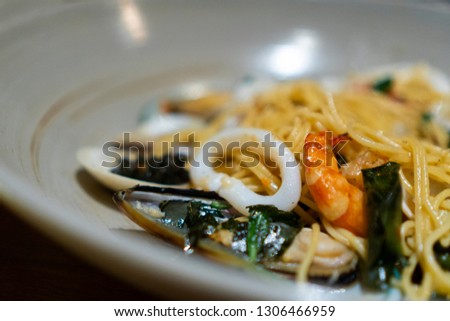 Close up seafood spaghetti with squid shrimp and big mussel serve with basil asia style at rooftop restaurant using for copy space or background food menu