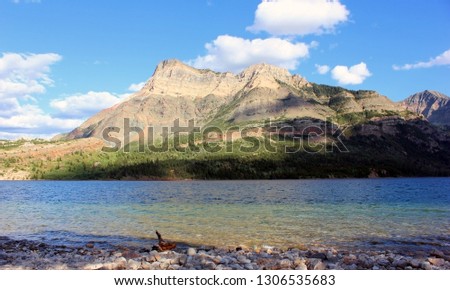 Beautiful lake in Waterton National Park, Alberta, Canada. Surrounded by mountains, stunning landscape. Very vibrant, colorful background picture.