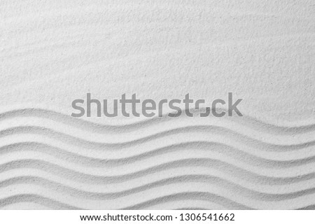 Zen garden pattern on sand as background, top view with space for text. Meditation and harmony Royalty-Free Stock Photo #1306541662
