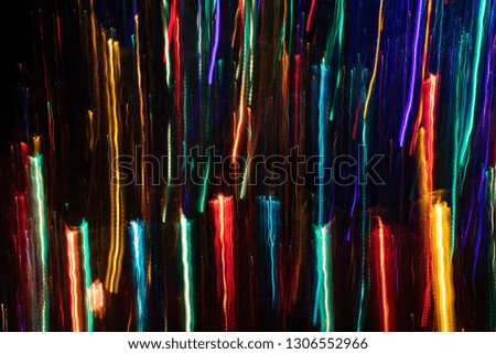 Multicolored vertical thin and thick glowing lines on black backdrop. 
