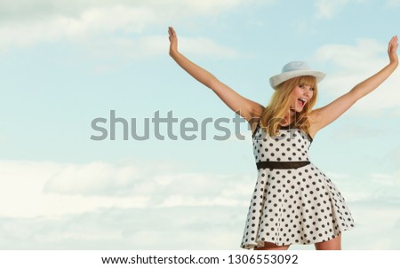 young joyful caucasian woman retro styling wearing polka dot dress hat outdoor sky background