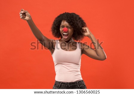Happy surprised and smiling african woman celebrating red nose day. Clown, fun, party, celebration, funny, joy, holiday, humor concept