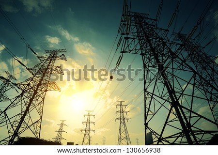 High-voltage power transmission towers in sunset sky background Royalty-Free Stock Photo #130656938