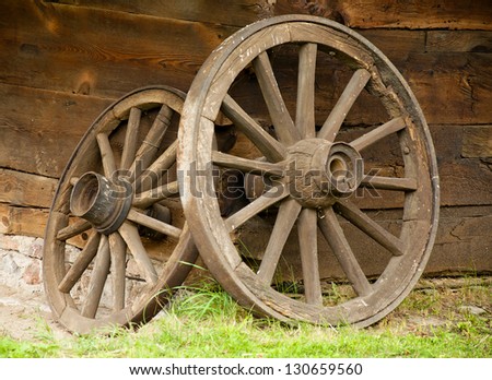Old wooden wheels in front of the cottage in small village. Poland, Europe