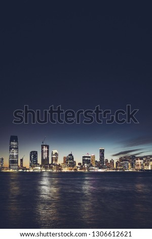 Jersey City skyline at night, color toning applied, space for text, USA.