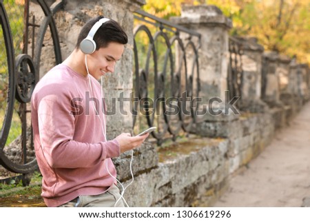 Young man listening to music outdoors