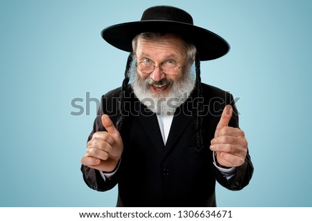Portrait of senior orthodox jewish man at studio. Purim, festival, holiday, celebration, judaism, religion, human emotions concept. Royalty-Free Stock Photo #1306634671
