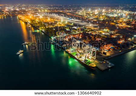 Night scene containers ship and ports freight load unloading by crane forwarding industry import export international worldwide, business services transportation of goods in ocean waters Asia Pacific 