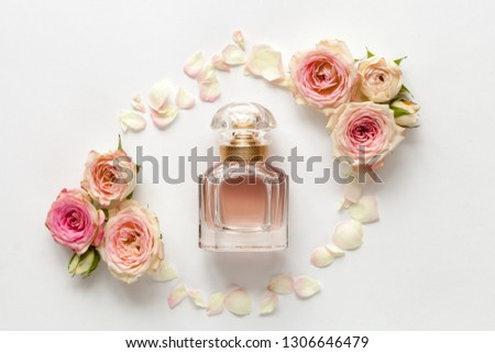 Parfume bottle with roses on white background. Top view.