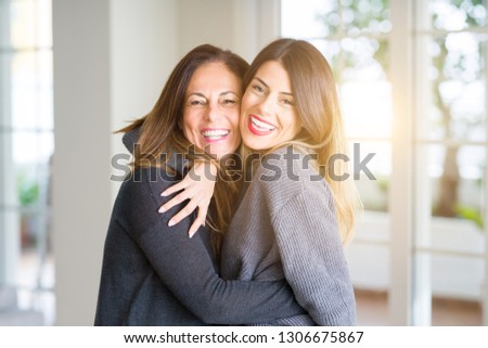 Beautiful family of mother and daughter together, hugging and kissing at home