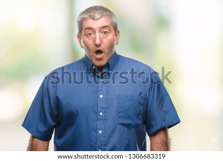 Handsome senior man over isolated background afraid and shocked with surprise expression, fear and excited face.