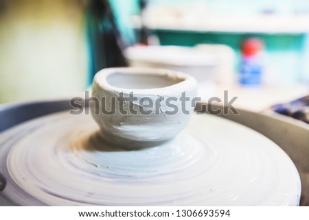 Clay bowl on pottery wheel at workshop.