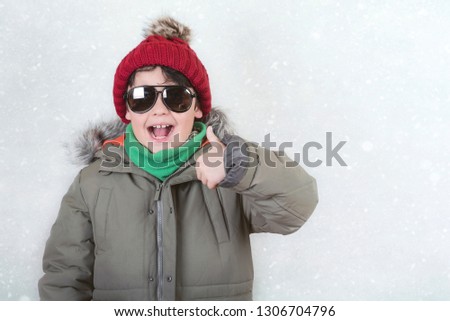 happy child with sunglasses and winter hat in winter holidays
