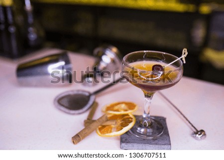 Top view of brown rum Cocktail drink with orange slice cinnamon tools barman beverage on a bar counter . Selective focus on the glass . Trendy stylish edit. Copy paste background service concept