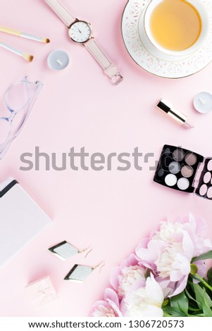 Beautiful cosmetics and flowers flat lay with note book, herbal tea on pastel background.
