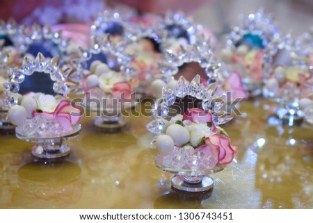 Elegant gifts made of mirror and candy for guests at a wedding or other celebration, decorated with flowers.
