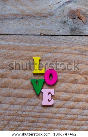 Love written in colorful wooden letters on a wood background