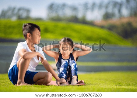 Little sporty boy and girl playing exercise or fitness outdoor, stretching muscle gymnastic