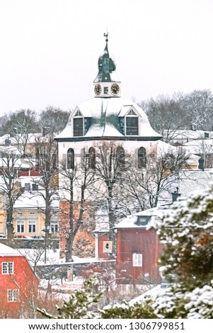 Old historic Porvoo, Finland with wooden houses and medieval stone and brick Porvoo Cathedral under white snow in winter.