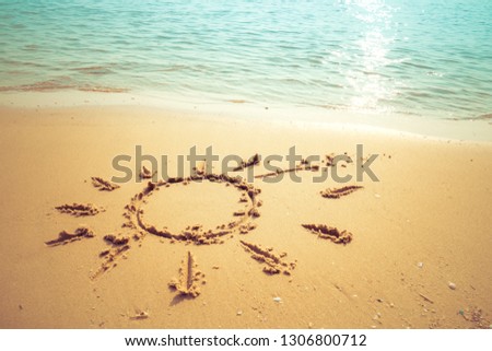 Vacation on the sand beach concept. The Sun symbol, sunshine drawing into the sand on the beach at Rayong, Thailand