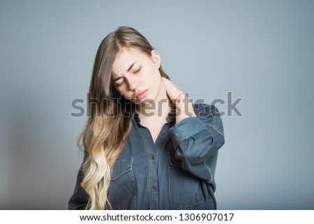 Beautiful blonde girl with neck pain, isolated on gray background