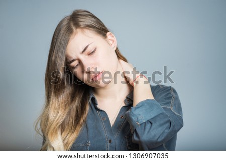 Beautiful blonde girl with neck pain, isolated on gray background