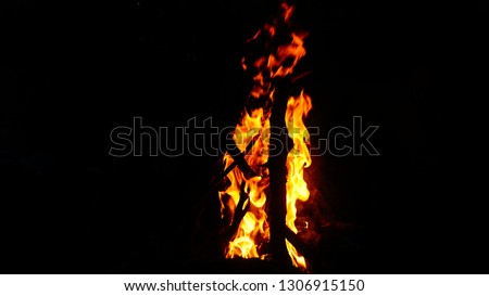 Fire flames of a campfire isolated on black background. High resolution wood fire flames collection smoke on warm beach night. Flame and fire sparks on dark abstract texture pattern background concept
