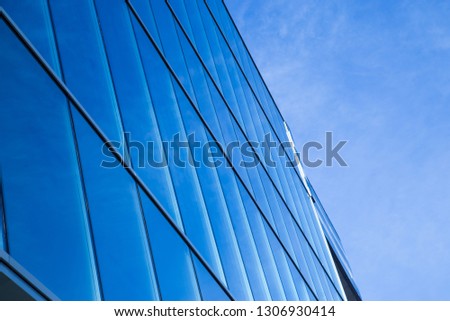 The wall of the building is made of glass. Modern architectural structure in the style of urban.