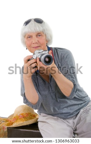 Elderly woman with a camera for travel and vacation photos. Grandma, Mom. Active pension. Retired. On a white background