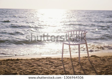 White chair placed on the beach, evening light.