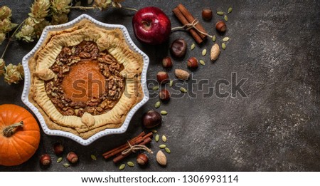 pumpkin pie with nuts, pumpkin seeds and Apple on dark background