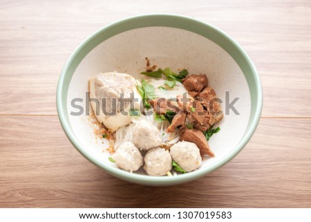 Dried noodles with pork boiled, pork meatball and tofu and pork meat in the bowl on the wood table in the Thailand 