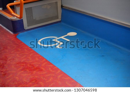 Disabled blue and white sign on floor of a public transport bus