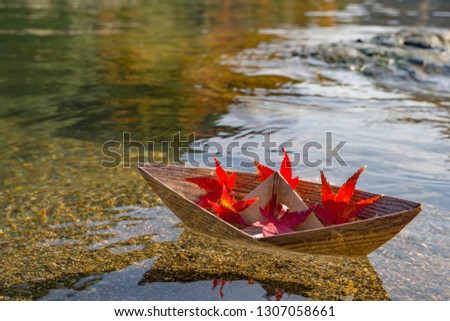Paper boat with sand and river background