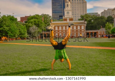 Philadelphia, Pennsylvania, USA - tourists on the grass in front of the Independence hall building in the city center of Philadelphia on a sunny summer day with tourists in front of it.