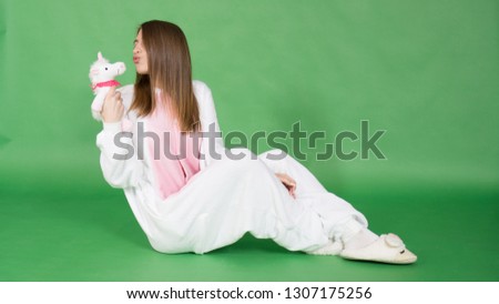 
Girl dressed as a unicorn on a green background.