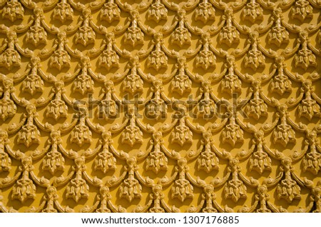 Stucco concrete of Thai pattern art, molded lime high relief of yellow texture wall background.