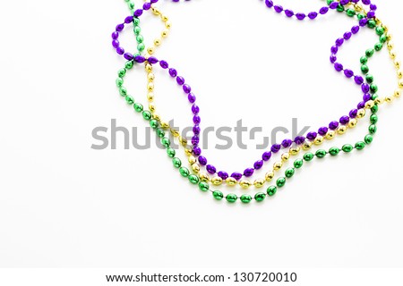 Mardi Gras beads and colorful masks on white backgound.