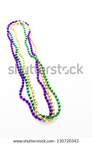 Multi color Mardi Gras beads on white background.