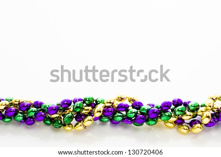 Multi color Mardi Gras beads on white background.