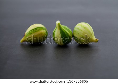 Fresh figs Bordissot Negra Rimada tree, producting its variegated and colorful fruits on dark rustic background, Flat lay. Nature concept, Free space