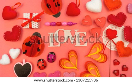 The word love of wood. The decor for the holiday Valentine's Day. Coral background. Heart ladybug.