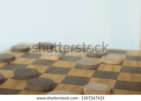 Wooden Checkerboard  and Checkers With Wooden Chair Against White Background