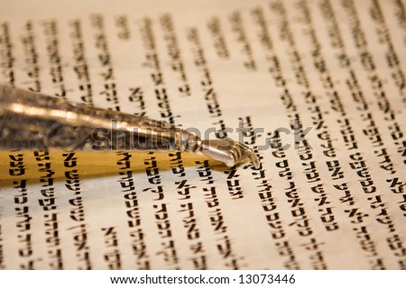 Reading a Torah scroll during a bar mitzvah ceremony with a traditional yad pointing towards the text on the parchment. Royalty-Free Stock Photo #13073446
