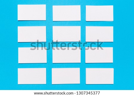 Blank white business cards on blue background. Mockup for branding identity. Template for graphic designers portfolios. Top view.